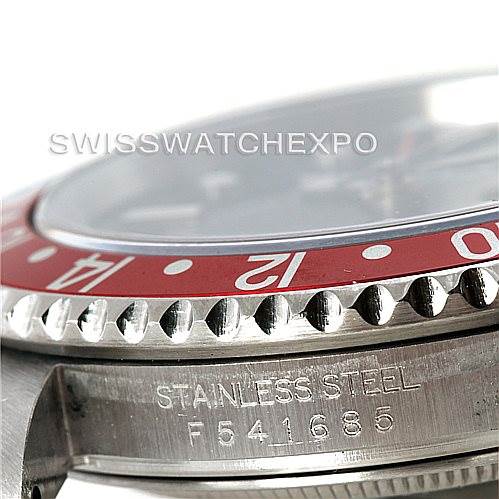 This image shows a close-up of the side of a Rolex GMT-Master 16710 Men's Stainless Steel Black Dial 16710 Men's Stainless Steel Black Dial, highlighting the red bezel, crown guard, and serial/metal engraving.