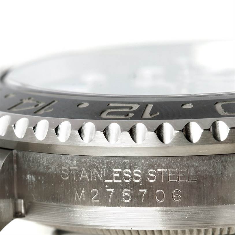 This image shows a close-up angled view of the bezel and case side of a Rolex GMT-Master 116710 Men
s Stainless Steel Black Dial 116710 Men
s Stainless Steel Black Dial with the "STAINLESS STEEL" engraving and serial number.