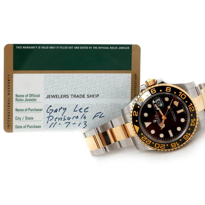 A Rolex GMT-Master 116713 Men's Stainless Steel Black Dial 116713 Men's Stainless Steel Black Dial watch is displayed semi-sideways, next to its warranty card showing purchase details.