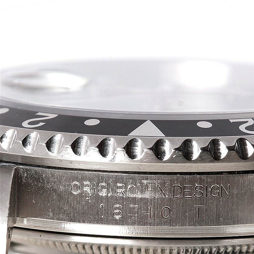This close-up image shows the bezel and case of a Rolex GMT-Master 16710 Men
s Stainless Steel Black Dial 16710 Men
s Stainless Steel Black Dial model with engravings, including the model number 16710.