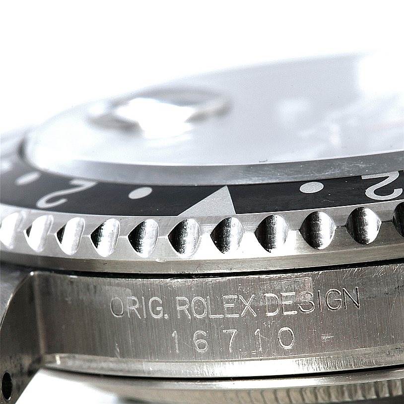 This close-up image of the Rolex GMT-Master 16710 Men
s Stainless Steel Black Dial 16710 Men
s Stainless Steel Black Dial watch shows the bezel, part of the case, and the engraving "ORIG. ROLEX DESIGN 16710."