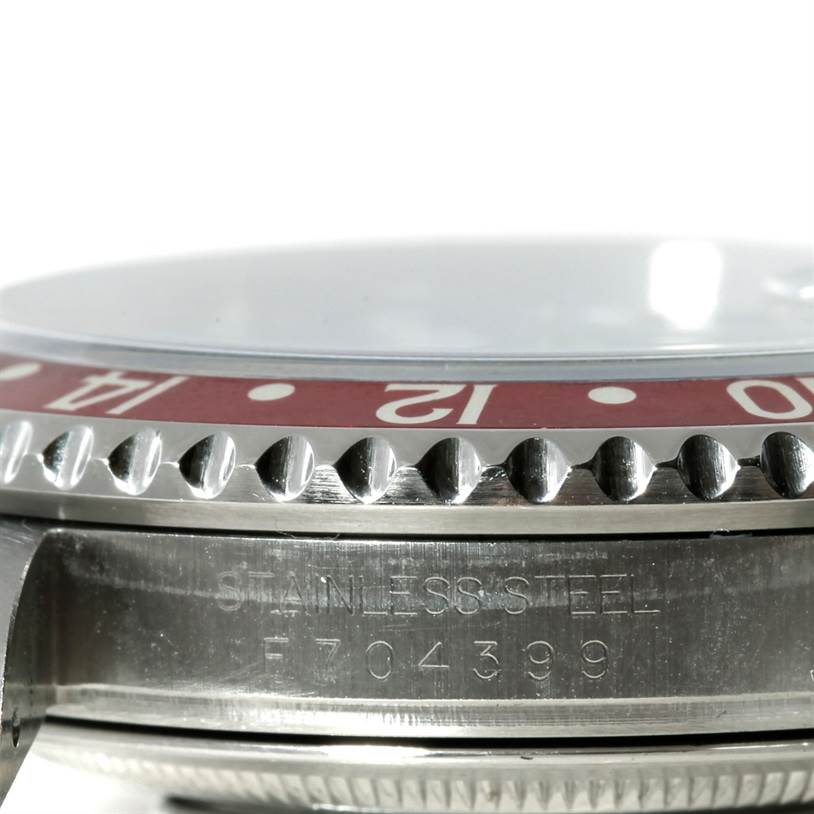 The image shows a close-up side view of a Rolex GMT-Master 16710 Men's Stainless Steel Black Dial 16710 Men's Stainless Steel Black Dial watch, focusing on the bezel, serial number, and stainless steel case.