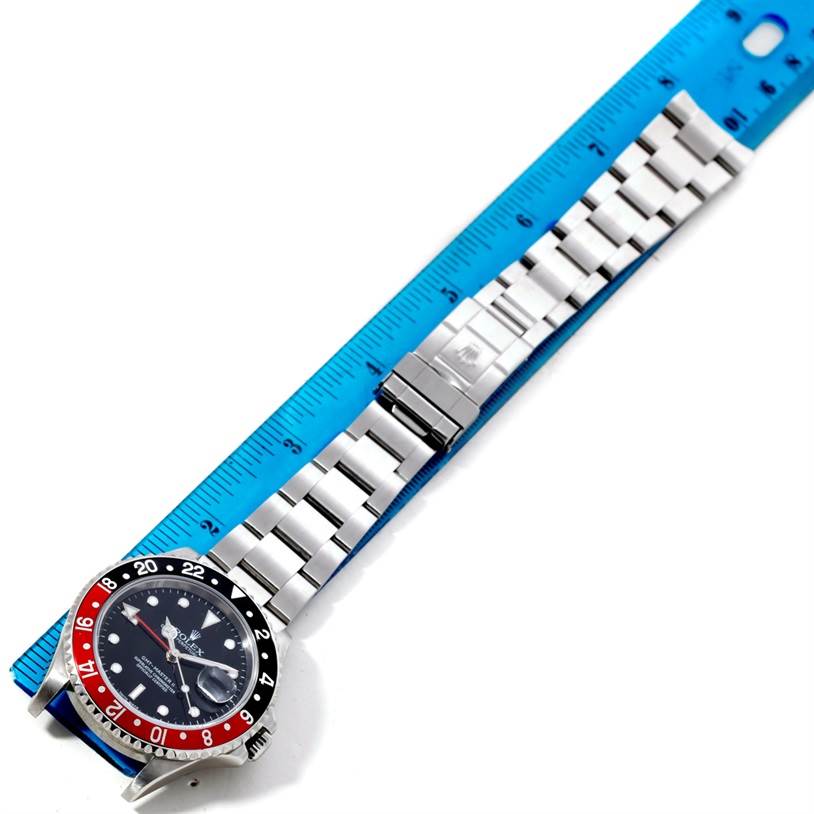 The image shows a Rolex GMT-Master 16710 Men's Stainless Steel Black Dial 16710 Men's Stainless Steel Black Dial watch laid flat, with its stainless steel bracelet extended next to a blue ruler for measurement.