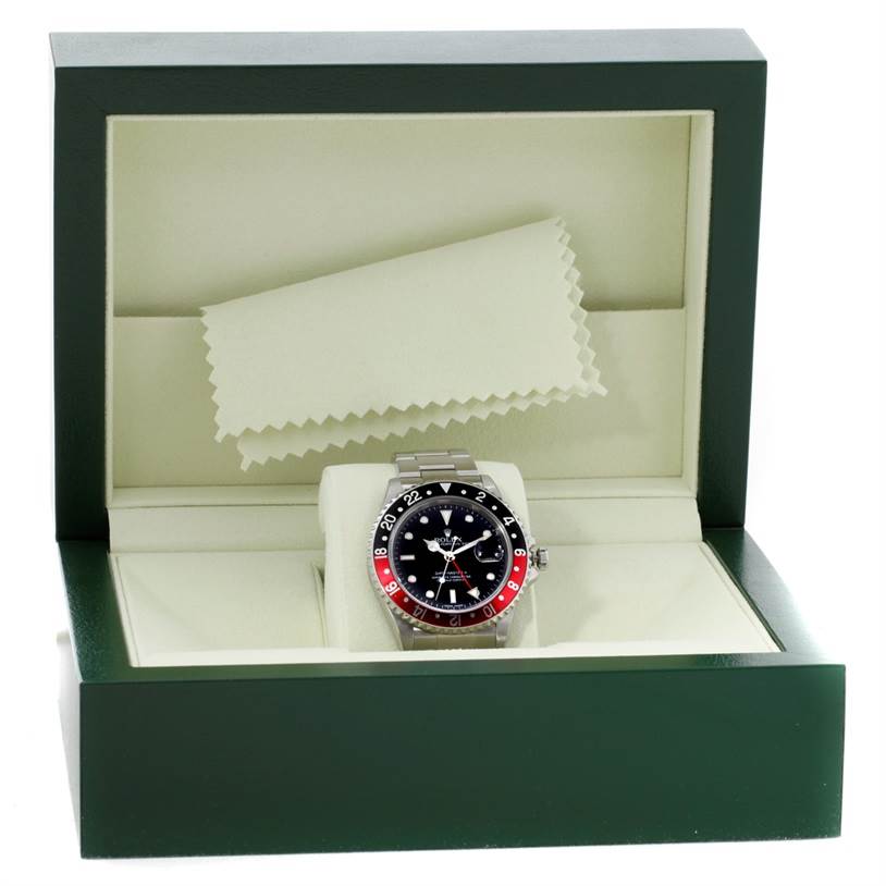 The image shows a Rolex GMT-Master 16710 Men's Stainless Steel Black Dial 16710 Men's Stainless Steel Black Dial watch from a front angle, inside its open green and cream colored watch box.