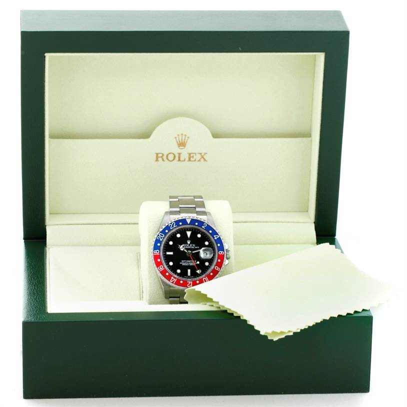 This image shows a Rolex GMT-Master 16710 Men's Stainless Steel Black Dial 16710 Men's Stainless Steel Black Dial watch inside an open green Rolex box with a cleaning cloth placed on the side.