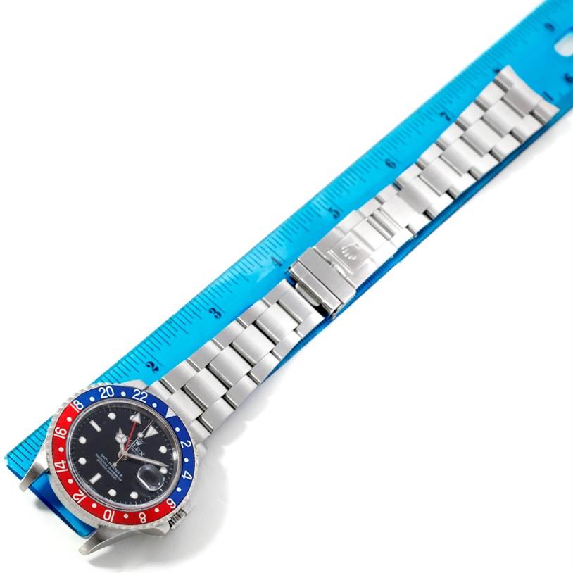 This image shows a top-down view of a Rolex GMT-Master 16710 Men's Stainless Steel Black Dial 16710 Men's Stainless Steel Black Dial watch, focusing on the watch face, bezel, and bracelet next to a ruler.