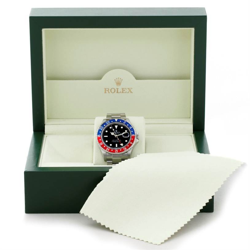 The Rolex GMT-Master 16710 Men's Stainless Steel Black Dial 16710 Men's Stainless Steel Black Dial watch is shown in its open green box with a cleaning cloth partially covering the bottom right corner.