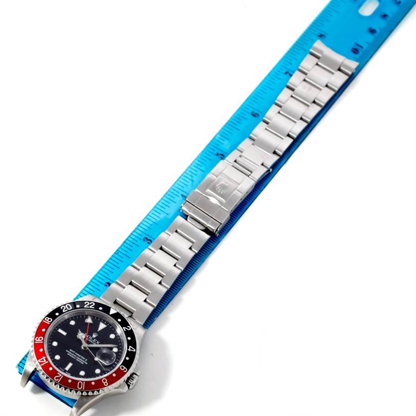 The image shows a Rolex GMT-Master 16710 Men's Stainless Steel Black Dial 16710 Men's Stainless Steel Black Dial watch laid flat with a metal bracelet, next to a blue measuring ruler.