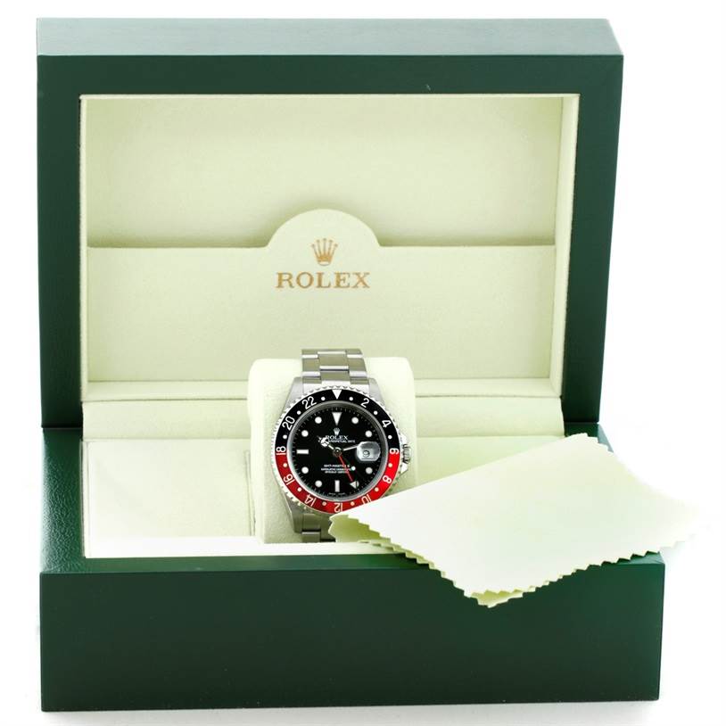 The Rolex GMT-Master 16710 Men's Stainless Steel Black Dial 16710 Men's Stainless Steel Black Dial watch is displayed front-on in an open box with a cloth beside it.