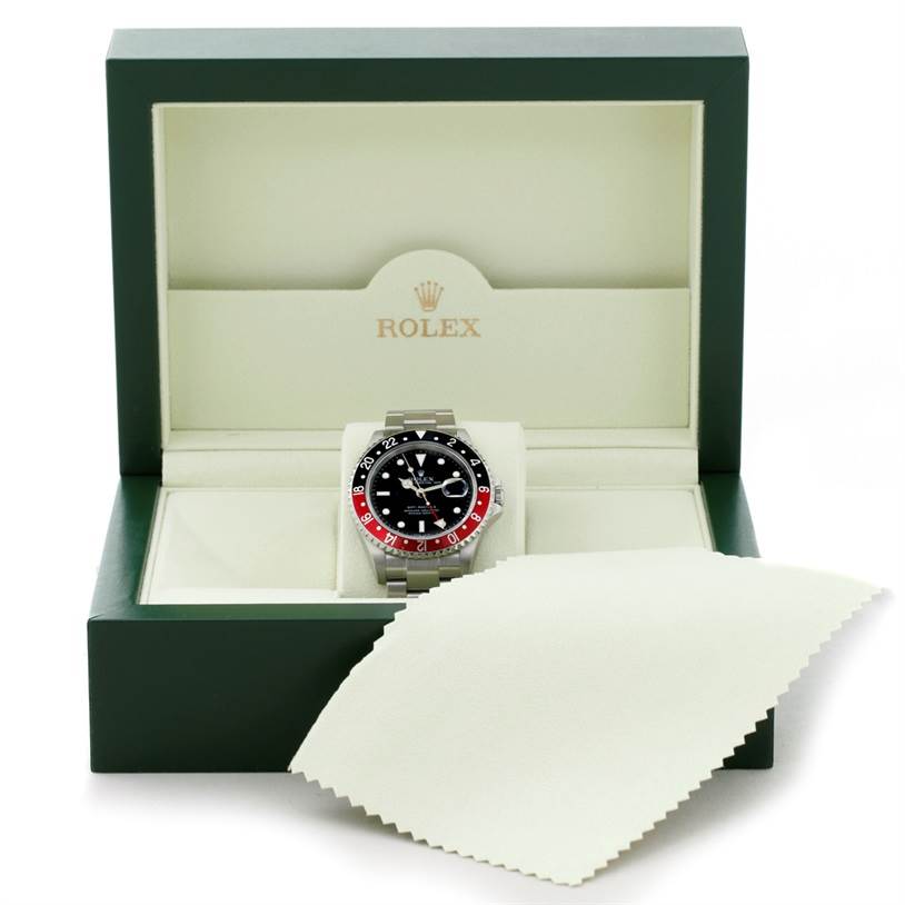 The Rolex GMT-Master 16710 Men's Stainless Steel Black Dial 16710 Men's Stainless Steel Black Dial watch is shown from the front, inside its open green box with a beige cleaning cloth.