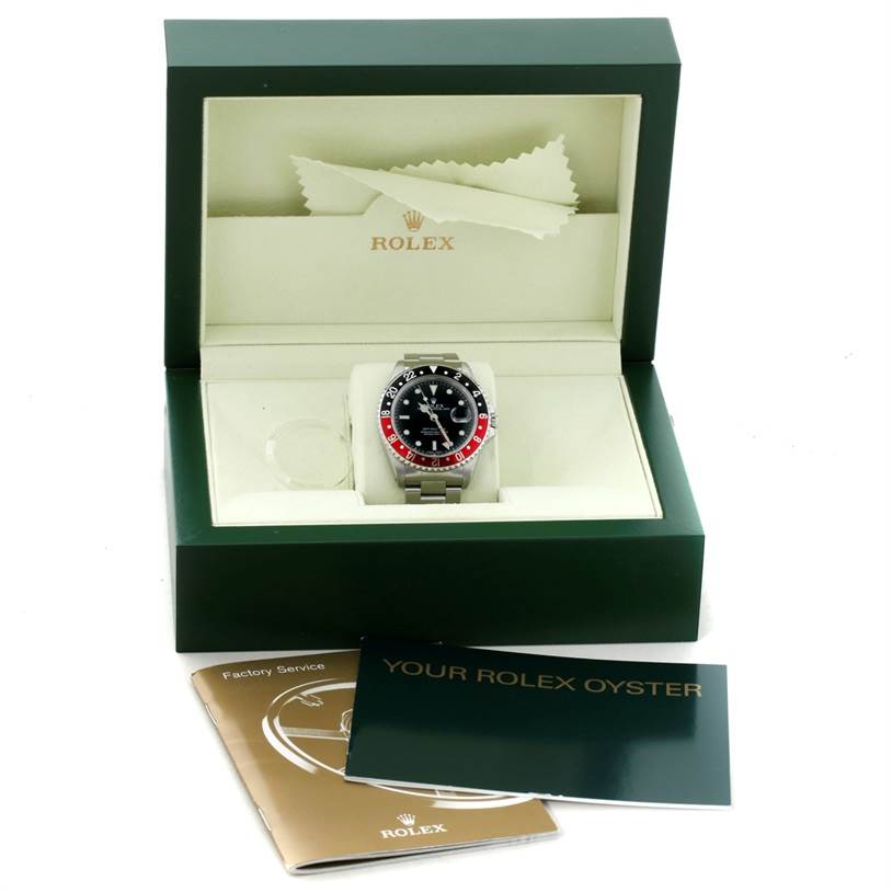 This image shows a Rolex GMT-Master 16710 Men's Stainless Steel Black Dial 16710 Men's Stainless Steel Black Dial watch, displayed in an open green box, with booklets placed in front.