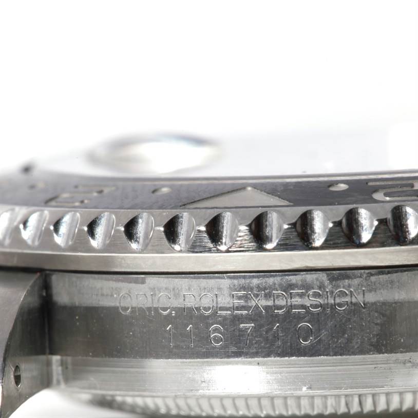 This close-up image of the Rolex GMT-Master 116710 Men's Stainless Steel Black Dial 116710 Men's Stainless Steel Black Dial watch shows the bezel edge and case side with "ORIG ROLEX DESIGN 116710" engraving.
