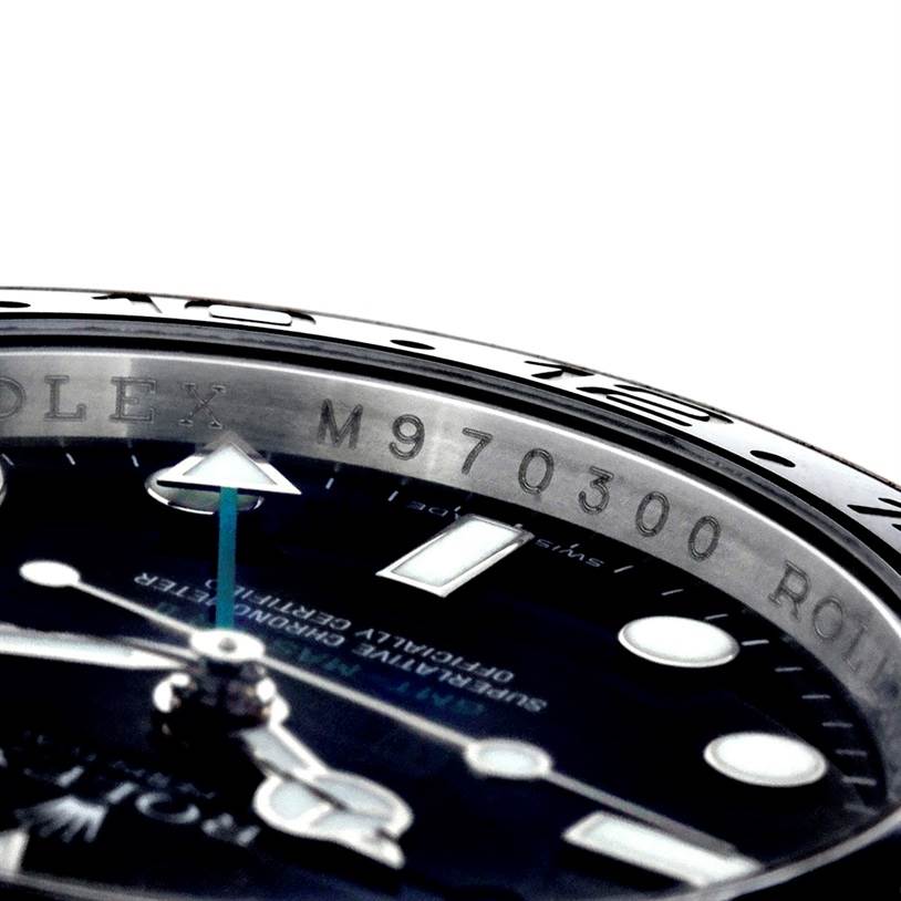 This close-up image of the Rolex GMT-Master 116710 Men's Stainless Steel Black Dial 116710 Men's Stainless Steel Black Dial watch shows a partial view of the dial, hands, and engraved inner bezel.