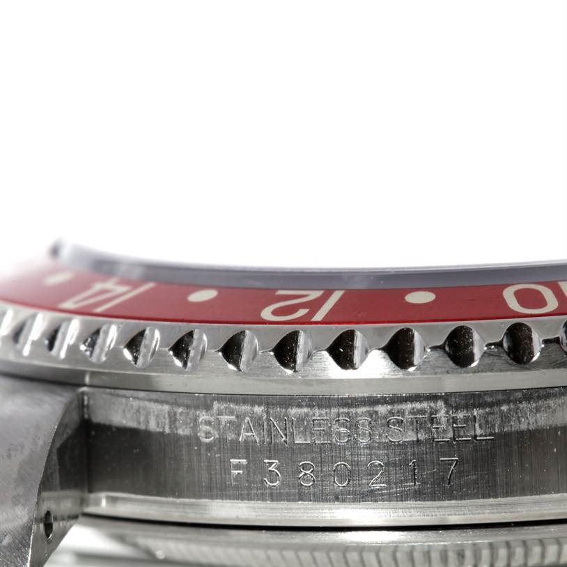 This close-up image of the Rolex GMT-Master 16710 Men's Stainless Steel Black Dial 16710 Men's Stainless Steel Black Dial watch focuses on part of the bezel, the side case, and the serial number.