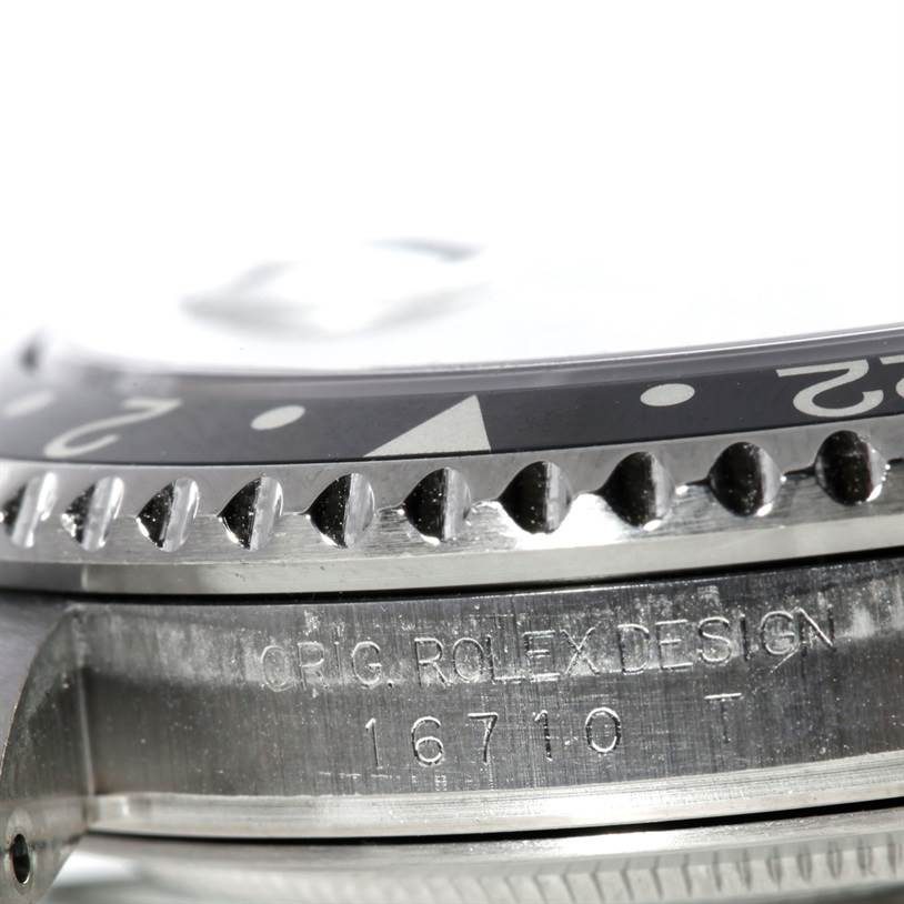The image shows a close-up side angle of the bezel and case of a Rolex GMT-Master 16710 Men's Stainless Steel Black Dial 16710 Men's Stainless Steel Black Dial model, highlighting its engraved details.
