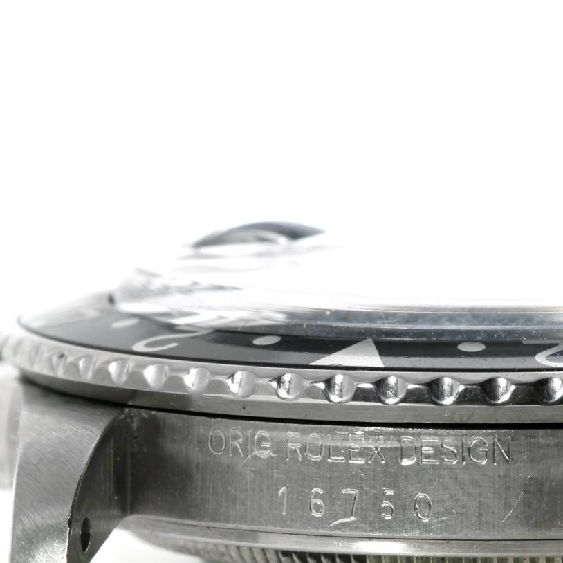 The image shows a close-up side view of the Rolex GMT-Master 16750 Men's Stainless Steel Black Dial 16750 Men's Stainless Steel Black Dial model, focusing on the bezel, crystal, and engraved case.