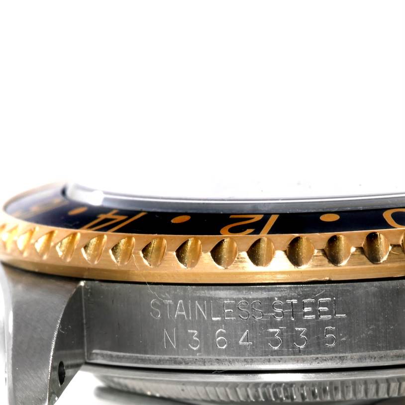 This image shows a close-up side view of the Rolex GMT-Master 16713 Men
s Stainless Steel Black Dial 16713 Men
s Stainless Steel Black Dial watch, featuring its bezel and a section of the case with engraved serial numbers.