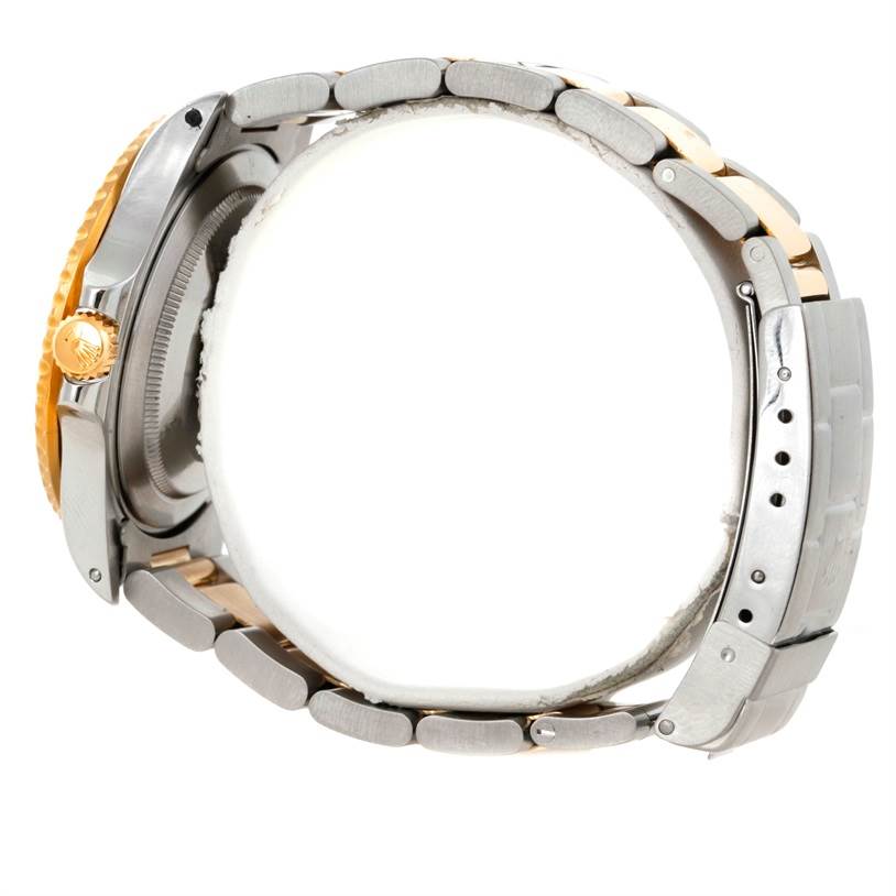 The image shows a side view of a Rolex GMT-Master 16713 Men
s Stainless Steel Black Dial 16713 Men
s Stainless Steel Black Dial watch, highlighting the crown and two-tone metal bracelet.