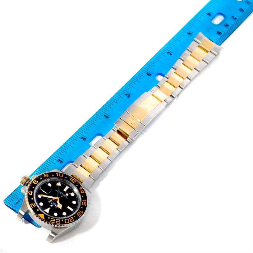 The image shows a Rolex GMT-Master 116713 Men's Stainless Steel Black Dial 116713 Men's Stainless Steel Black Dial watch laid flat next to a ruler, displaying the watch face, bezel, and bracelet prominently.