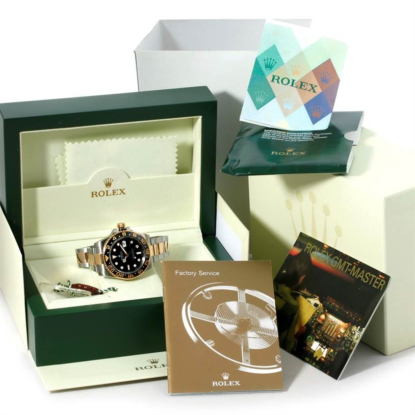 This image shows a Rolex GMT-Master 116713 Men's Stainless Steel Black Dial 116713 Men's Stainless Steel Black Dial watch in a green display box with accompanying booklets and accessories.