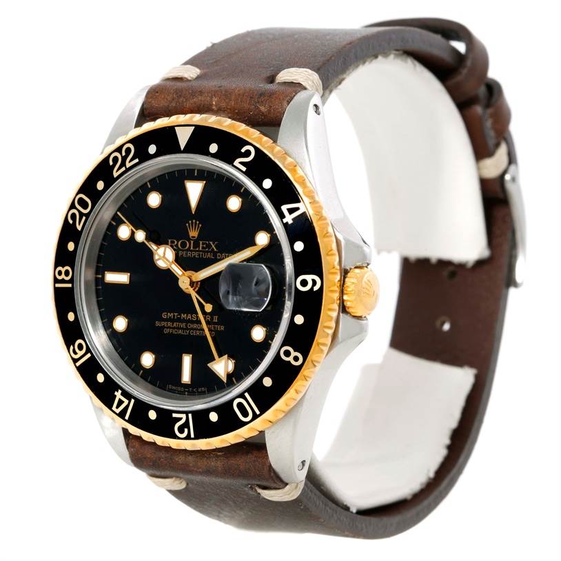 The Rolex GMT-Master 16713 Men's Stainless Steel Black Dial 16713 Men's Stainless Steel Black Dial watch is shown at a slight side angle, displaying its black dial, gold accents, and leather strap.