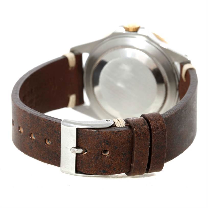 The image shows the back of a Rolex GMT-Master 16713 Men's Stainless Steel Black Dial 16713 Men's Stainless Steel Black Dial watch with a brown leather strap and a silver buckle.