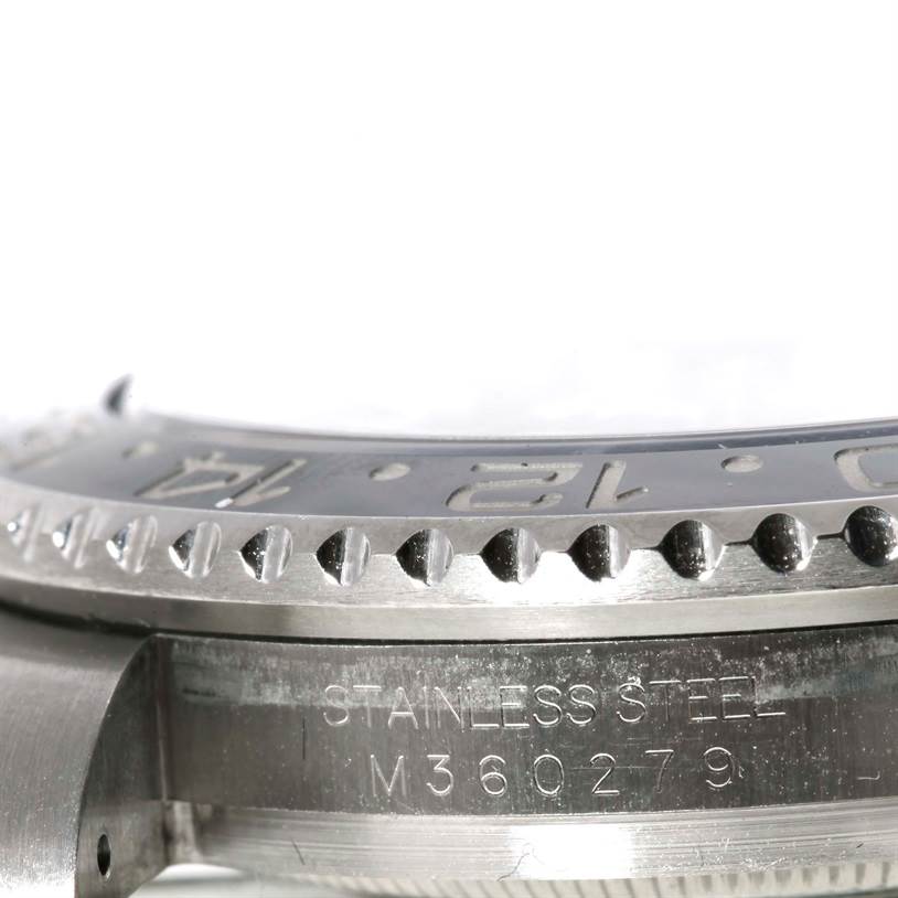 This close-up image shows the stainless steel bezel and engraved serial number on a Rolex GMT-Master 116710 Men's Stainless Steel Black Dial 116710 Men's Stainless Steel Black Dial watch.