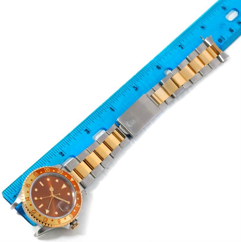 The image shows a side angle of the Rolex GMT-Master 16713 Men's Stainless Steel Brown Dial 16713 Men's Stainless Steel Brown Dial watch, featuring its face, bezel, and two-tone metal bracelet.