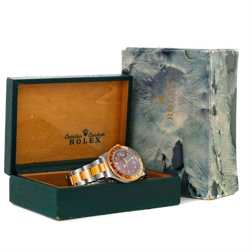 The image shows a Rolex GMT-Master 16713 Men's Stainless Steel Brown Dial 16713 Men's Stainless Steel Brown Dial watch angled inside its open green and wood box, with the outer packaging alongside.