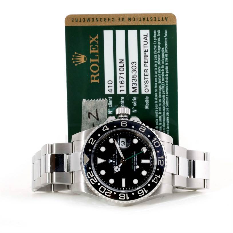 The image shows a front-facing Rolex GMT-Master 116710 Men's Stainless Steel Black Dial 116710 Men's Stainless Steel Black Dial watch with its identification card behind it.
