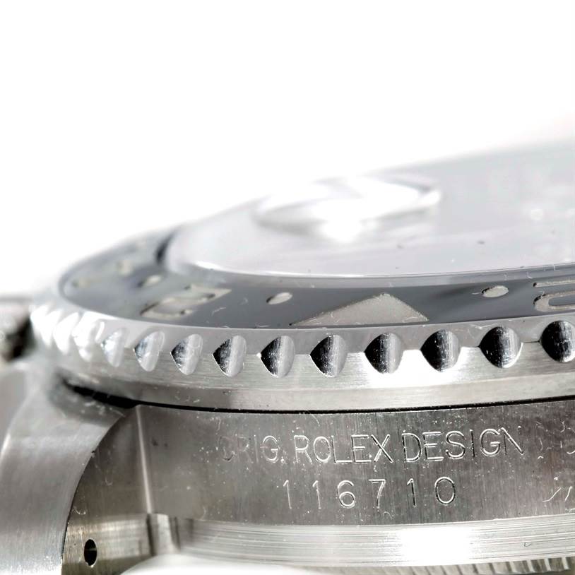 This image shows a close-up angle of the bezel and side detailing, including engraved text, of the Rolex GMT-Master 116710 Men's Stainless Steel Black Dial 116710 Men's Stainless Steel Black Dial watch.
