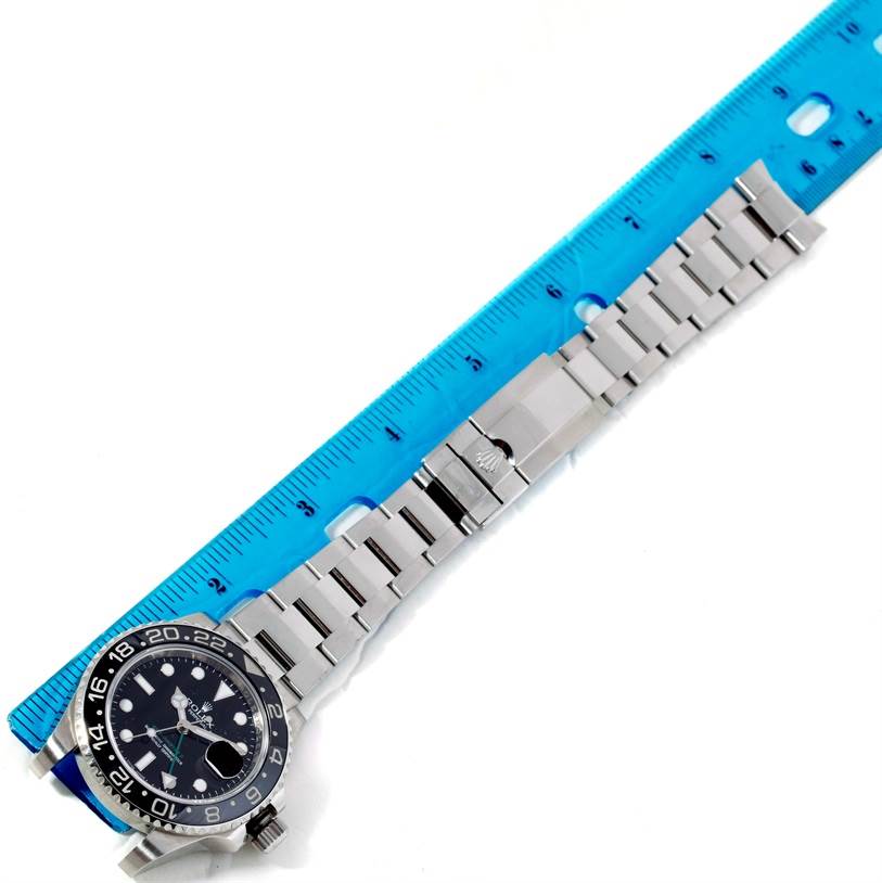 The image shows a top-down view of a Rolex GMT-Master 116710 Men's Stainless Steel Black Dial 116710 Men's Stainless Steel Black Dial watch, measuring its bracelet with a blue ruler.