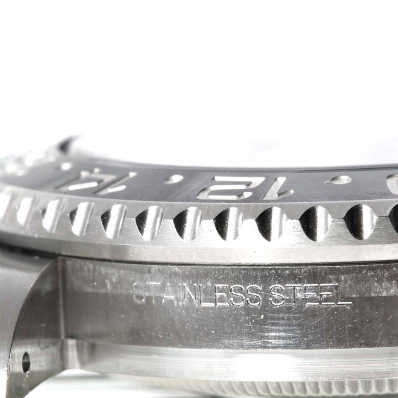 This image shows a close-up side angle of the stainless steel bezel and part of the case of a Rolex GMT-Master 116710 Men's Stainless Steel Black Dial 116710 Men's Stainless Steel Black Dial watch.