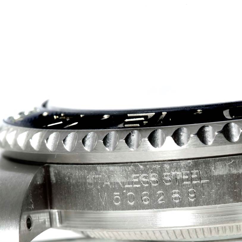 The image shows a close-up side view of a Rolex GMT-Master 116710 Men's Stainless Steel Black Dial 116710 Men's Stainless Steel Black Dial's stainless steel case and bezel with an engraved serial number.