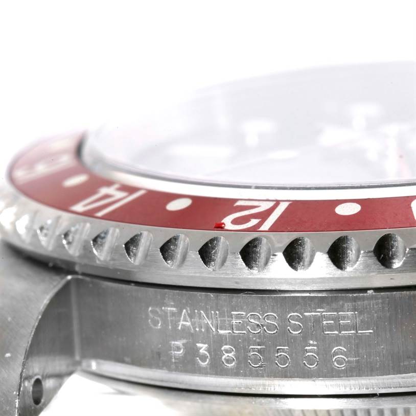 The image shows a close-up side view of the bezel and lugs of a Rolex GMT-Master 16710 Men's Stainless Steel Black Dial 16710 Men's Stainless Steel Black Dial watch, highlighting its red bezel and serial number.