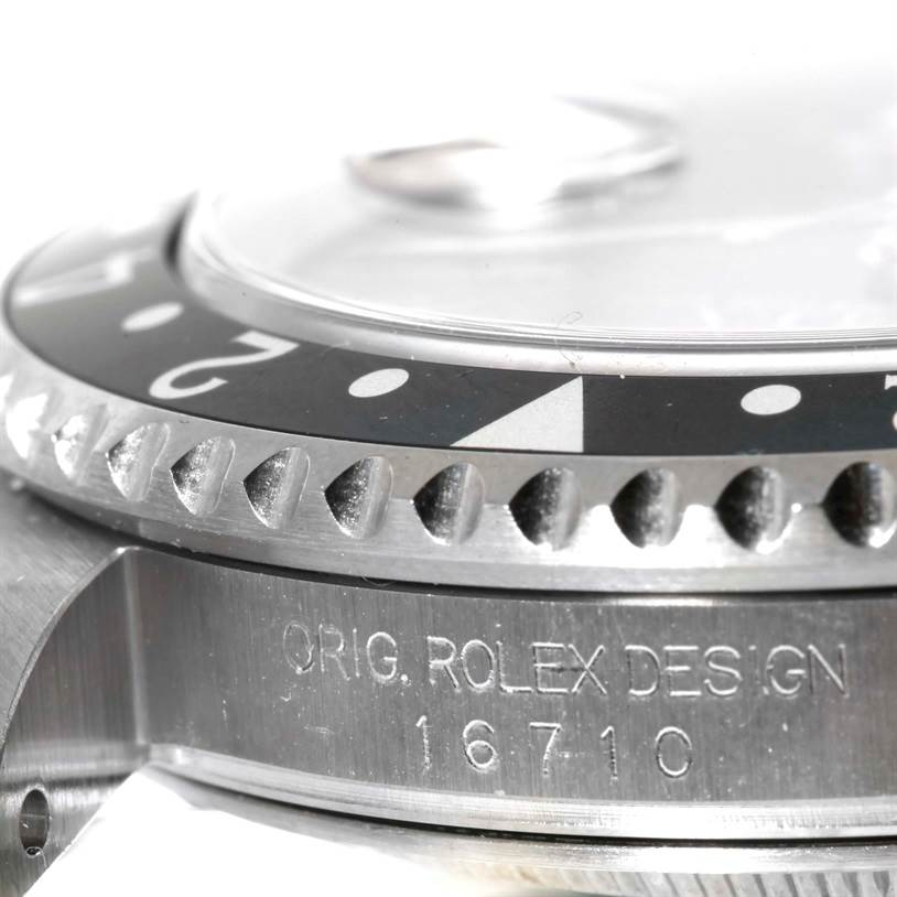 The image shows a close-up angle of the bezel, case, and serial engraving of a Rolex GMT-Master 16710 Men's Stainless Steel Black Dial 16710 Men's Stainless Steel Black Dial model 16710.