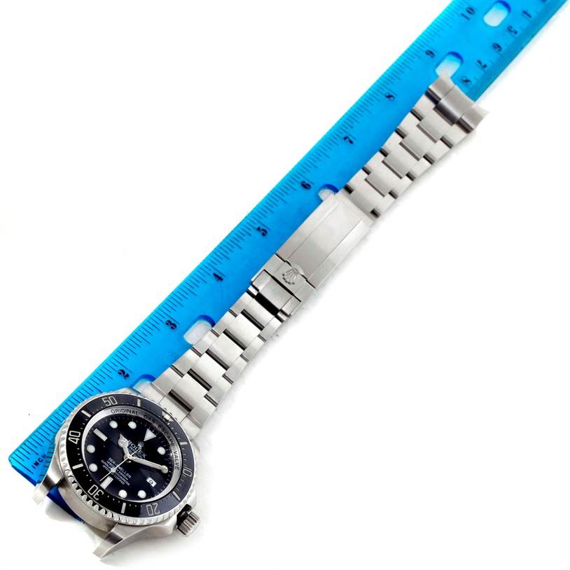 The image shows a top-down view of the Rolex Sea-Dweller 116660 Men's Stainless Steel Black Dial 116660 Men's Stainless Steel Black Dial watch, including its face, bezel, and stainless steel bracelet next to a ruler.