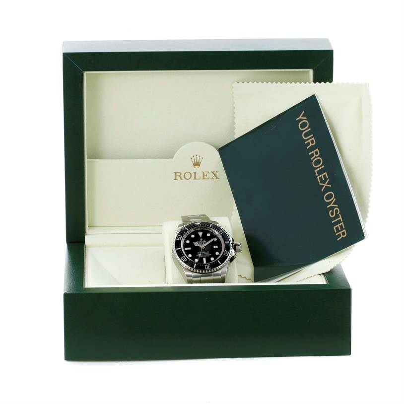 The Rolex Sea-Dweller 116660 Men's Stainless Steel Black Dial 116660 Men's Stainless Steel Black Dial watch is displayed in its open box, with accompanying cloth and instruction booklet visible.
