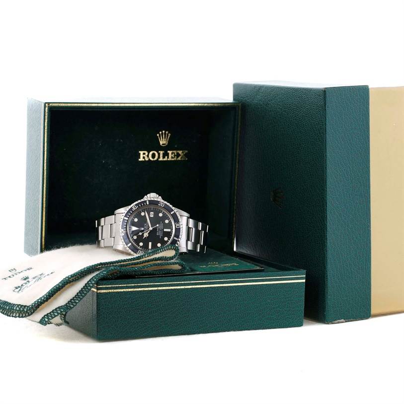 The image shows a Rolex Sea-Dweller 1665 Men's Stainless Steel Black Dial 1665 Men's Stainless Steel Black Dial watch, with a frontal view, positioned in its green box, accompanied by its accessories.