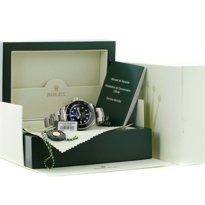 The image shows a Rolex Sea-Dweller 116660 Men
s Stainless Steel Blue Dial 116660 Men
s Stainless Steel Blue Dial watch, displayed in its open box with manuals, a tag, and an extra bracelet link.