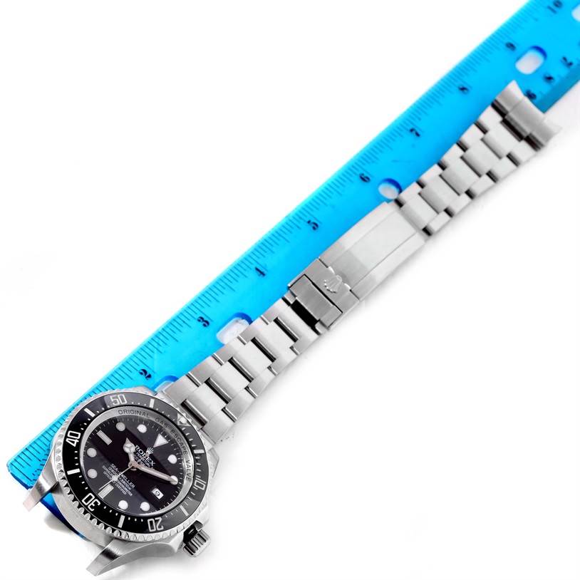 The image shows the Rolex Sea-Dweller 116600 Men's Stainless Steel Black Dial 116600 Men's Stainless Steel Black Dial watch at an angled top view, including the face, bezel, and stainless steel bracelet near a ruler.