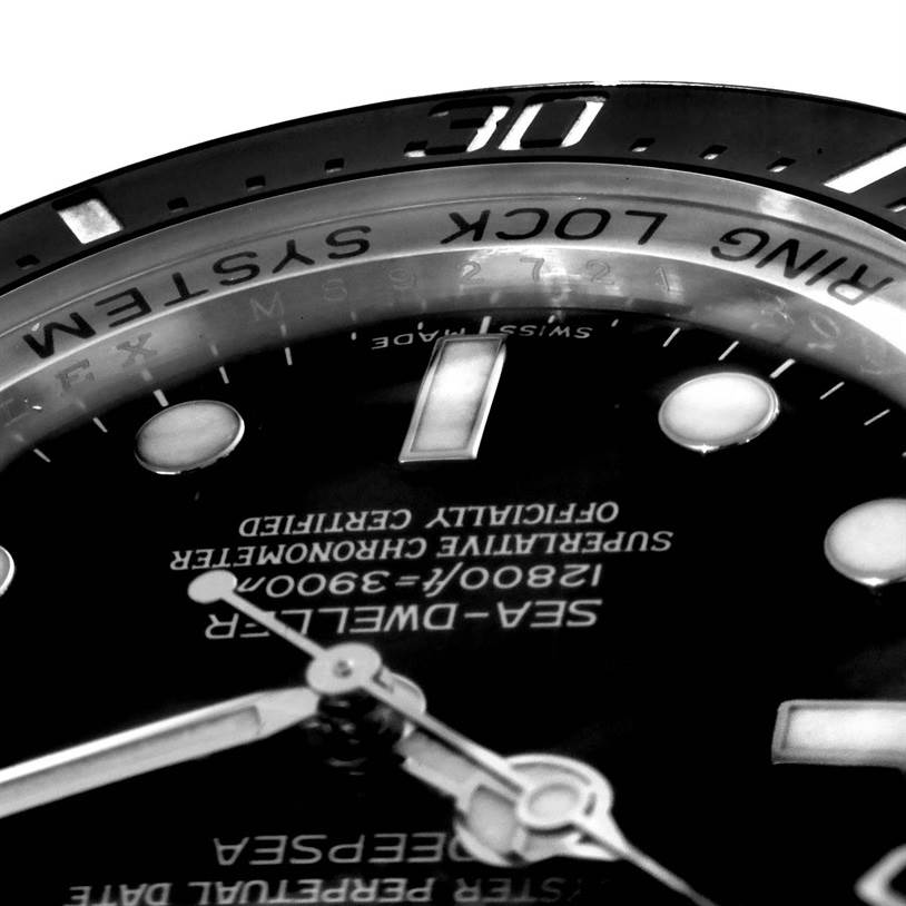 The image shows a close-up angled view of the dial and bezel of the Rolex Sea-Dweller 116600 Men's Stainless Steel Black Dial 116600 Men's Stainless Steel Black Dial watch, highlighting its text and markers.