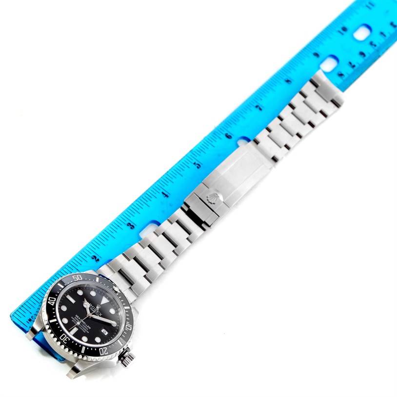 This image shows an overhead view of a Rolex Sea-Dweller 116600 Men's Stainless Steel Black Dial 116600 Men's Stainless Steel Black Dial watch next to a ruler, highlighting the watch's face and stainless steel bracelet.