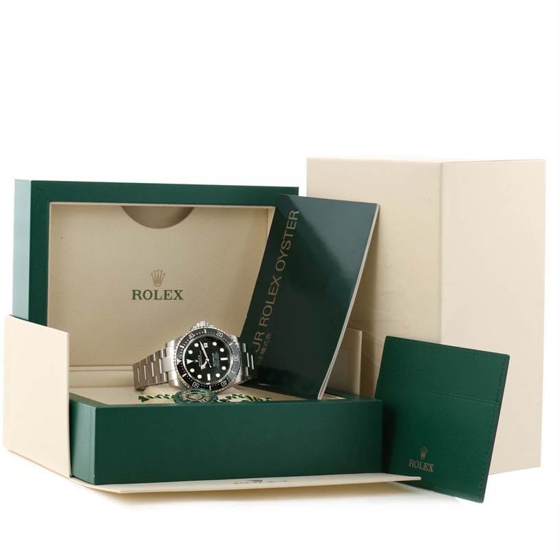 The image shows the Rolex Sea-Dweller 116600 Men's Stainless Steel Black Dial 116600 Men's Stainless Steel Black Dial watch partially inside its open box with accompanying booklets and packaging.