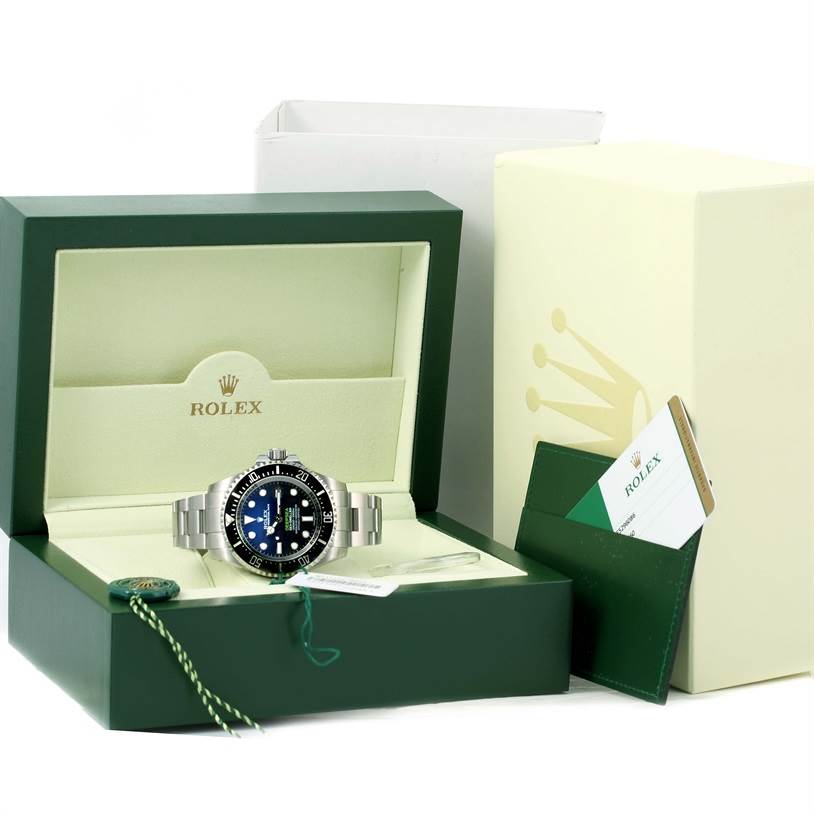 This image shows a Rolex Sea-Dweller 116660 Men
s Stainless Steel Blue Dial 116660 Men
s Stainless Steel Blue Dial watch presented in its open box with accompanying tags and documentation.
