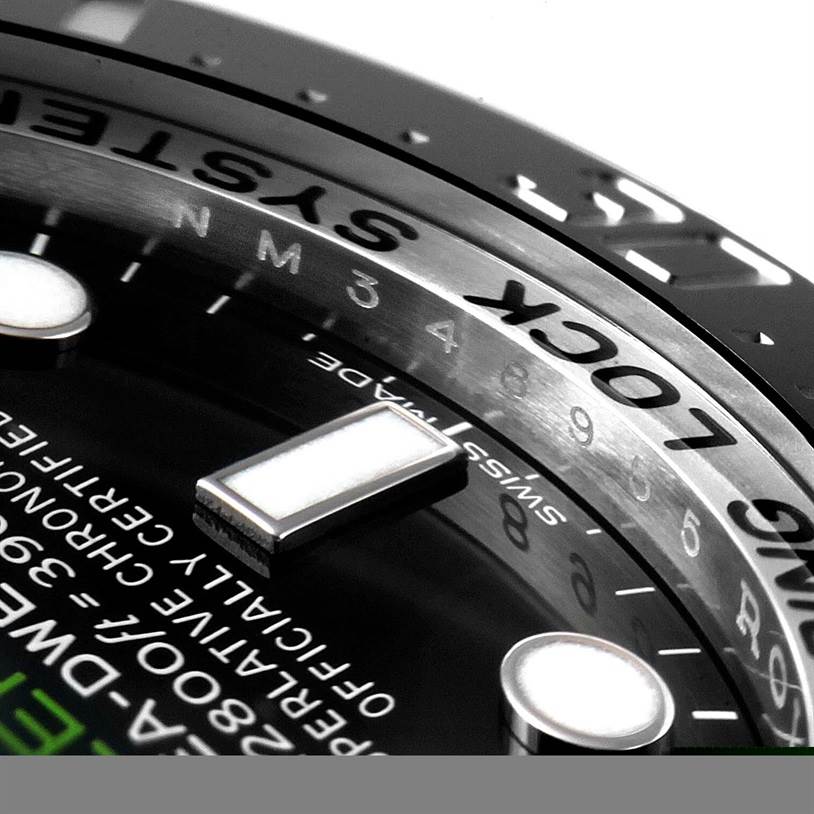 This close-up image of the Rolex Sea-Dweller 116660 Men's Stainless Steel Blue Dial 116660 Men's Stainless Steel Blue Dial watch shows the bezel, part of the dial, and luminescent markers.