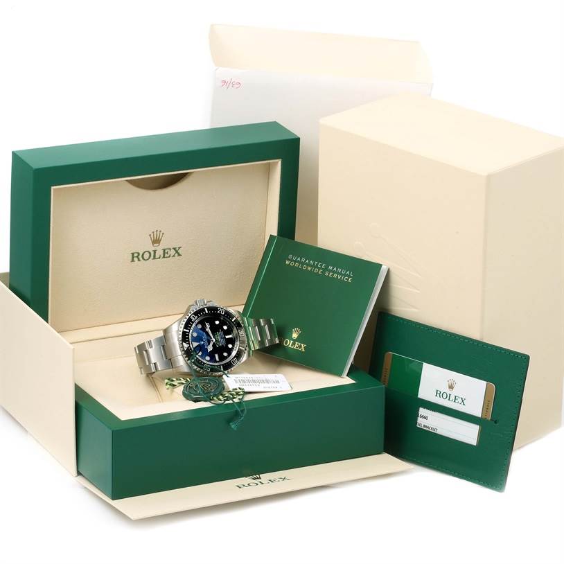 The image shows a Rolex Sea-Dweller 116660 Men's Stainless Steel Blue Dial 116660 Men's Stainless Steel Blue Dial watch with its box, guarantee manual, and warranty card holder from a front angle.