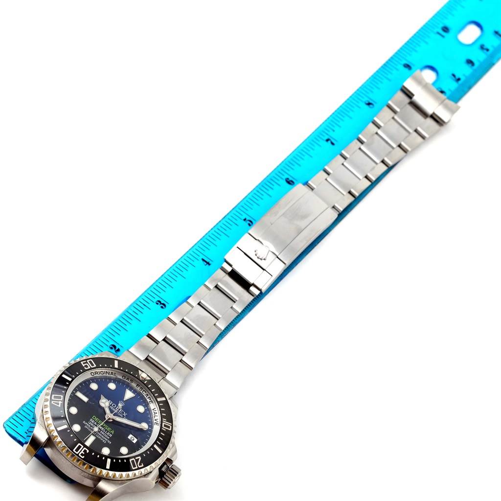 The image shows a Rolex Sea-Dweller 116660 Men's Stainless Steel Blue Dial 116660 Men's Stainless Steel Blue Dial watch laid flat with its stainless steel bracelet extended alongside a blue ruler for measurement.
