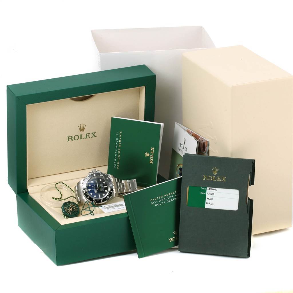 The image shows a Rolex Sea-Dweller 116660 Men's Stainless Steel Blue Dial 116660 Men's Stainless Steel Blue Dial watch at an angle, with its box, manuals, and warranty card included.