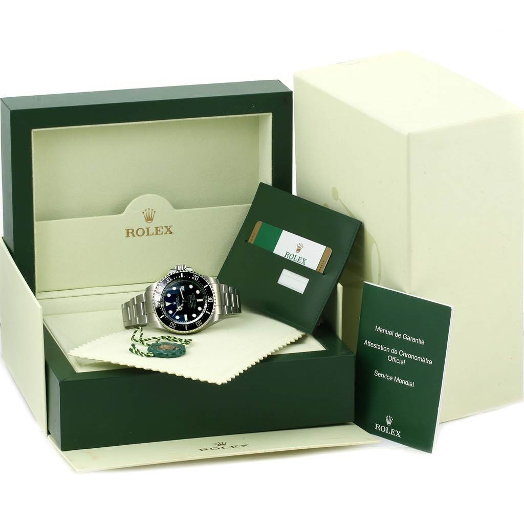 This image shows a front-angle view of a Rolex Sea-Dweller 116660 Men's Stainless Steel Blue Dial 116660 Men's Stainless Steel Blue Dial watch with its box, warranty card, and service manual.